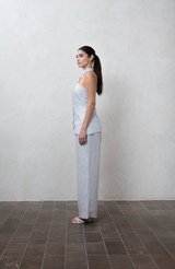 Asymmetric greige one-shoulder top with white buttons