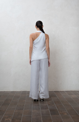 Asymmetric greige one-shoulder top with white buttons